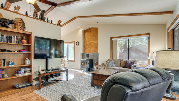 Una sala de estar amplia con chimenea, televisor y estantería.