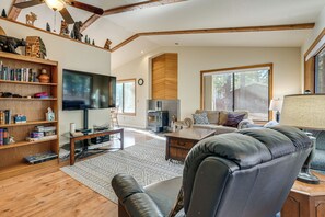 Ein geräumiges Wohnzimmer mit Kamin, Fernseher und Bücherregal.