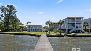 A wooden dock leading to a marina with buildings on either side. - Tranquil 2-bedroom condo with Wolf bay views (Orange Beach)