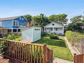 Een woonhuis met een blauw huis, een witte schuur en een veranda.