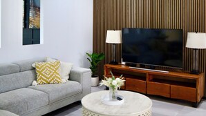 A modern living room with a grey sofa, a round coffee table, a flat-screen TV, and a ceiling fan. - Two Williams Estate - Hunter Valley
4 Bedrooms, 2 Bathrooms, Pool Table (Kitchener)