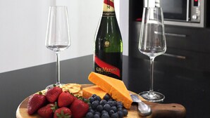 A modern kitchen with a wooden cutting board holding strawberries, blueberries, and cheese, a bottle of champagne, and two empty wine glasses. - Two Williams Estate - Hunter Valley
4 Bedrooms, 2 Bathrooms, Pool Table (Kitchener)