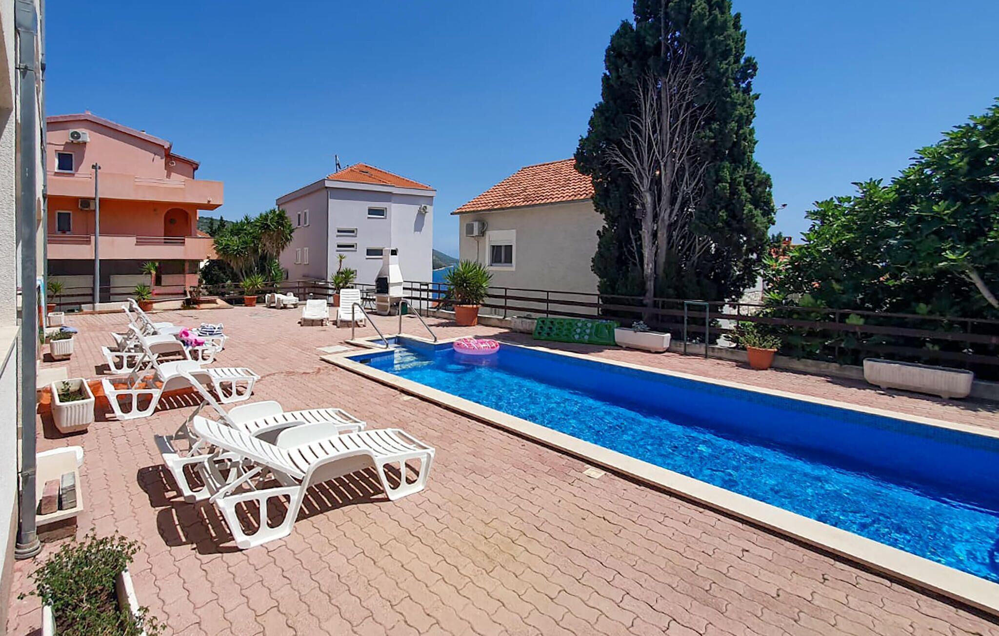 Ein Schwimmbecken mit Liegestühlen und Topfpflanzen.