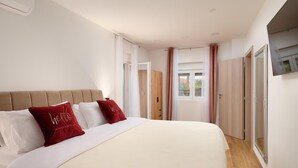 Une chambre à coucher avec un lit, une armoire, un miroir et une fenêtre.