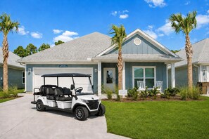 A two-story house with a garage, a golf cart, and palm trees. - Fall Special! Sleeps 10•Golf Cart•Pool•Beach (Port St. Joe)