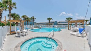 A pool area with lounge chairs, a hot tub, and a wooden pergola. - Tropical Heaven - Unit 1600 - Island Dunes Condos (Port Aransas)