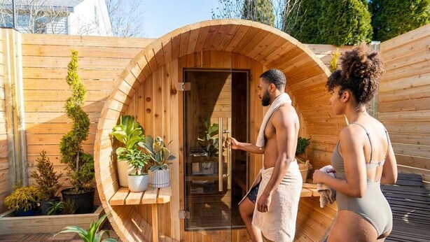 A wooden sauna with a glass door, surrounded by potted plants and a wooden deck. - Warren 1BR Retreat + Spa | Walk to Dining & Water (Warren)