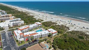 An aerial view of a coastal hotel with multiple buildings, a parking lot, and a beach. - Beachfront Getaway in St. Augustine (St. Augustine)