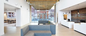 A modern hotel lobby with a reception desk, seating area, and large windows offering views of the outdoor area. - Spacious newly built 2-bedroom condo with AC in charming Moab (Moab)
