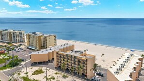 Un hotel con diversi piani, affaccio sulla spiaggia e un'area di parcheggio.