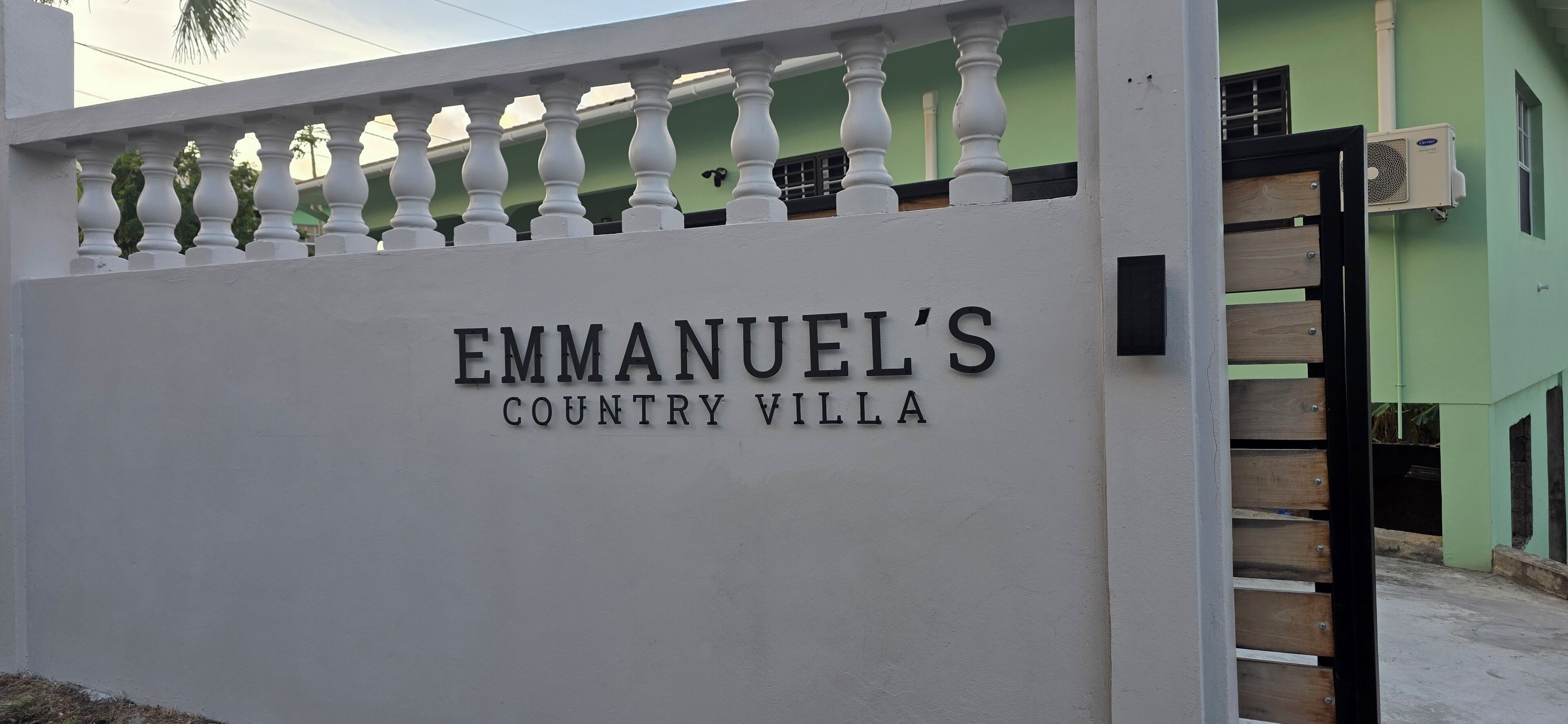 A white wall with 'EMMANUEL'S COUNTRY VILLA' signage.