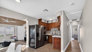 Une cuisine moderne avec des meubles en bois, des appareils en acier inoxydable et un îlot central.