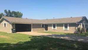 A two-story house with a garage, a front lawn, and a driveway.