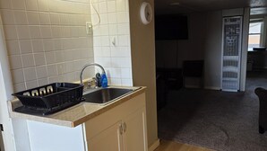 A compact kitchen with a sink, a small trash bin, and a refrigerator. - Cozy 1-bedroom apartment in fantastic Mount Pleasant with AC (Mount Pleasant)