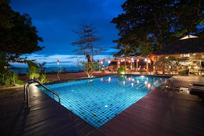 A swimming pool with a tiled deck, surrounded by lounge chairs and a covered seating area with string lights. - Lalaanta Hideaway Resort (Ko Lanta)