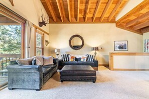 Ein gemütliches Wohnzimmer mit Kamin, zwei Sofas, einem Couchtisch und einem großen Spiegel an der Wand.