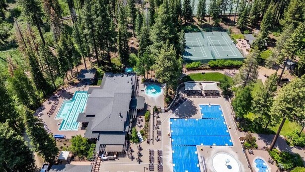 An aerial view of a resort with multiple swimming pools, tennis courts, and a large building with a roof. - Northstar Studio near village and slopes (Truckee)