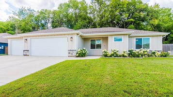A two-story house with a garage, a front lawn, and a driveway.