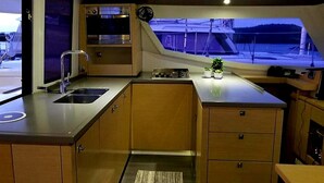 Une cuisine de taille réduite, équipée d’un évier, d’une cuisinière et de meubles de rangement en bois.