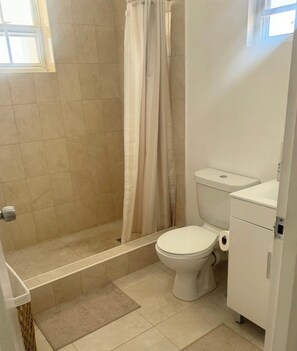 Een douche, een haardroger, handdoeken, toiletpapier