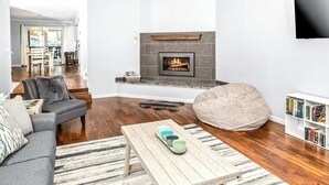 Ein modernes Wohnzimmer mit Kamin, Sofa, Sitzsack, Couchtisch und Bücherregal.