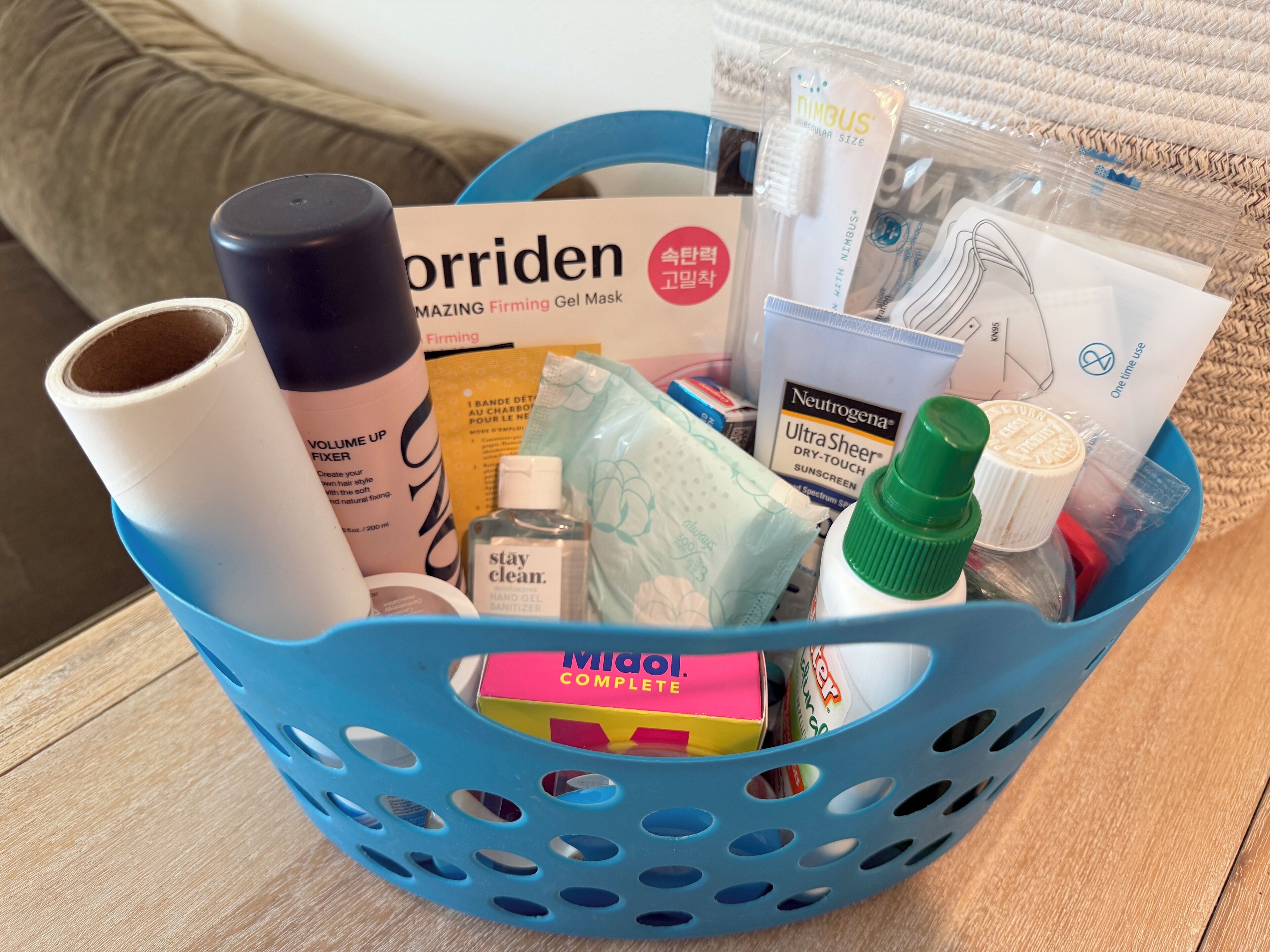 A basket containing various personal care items including a hair styling product, a hand sanitizer, and a facial cleansing product.