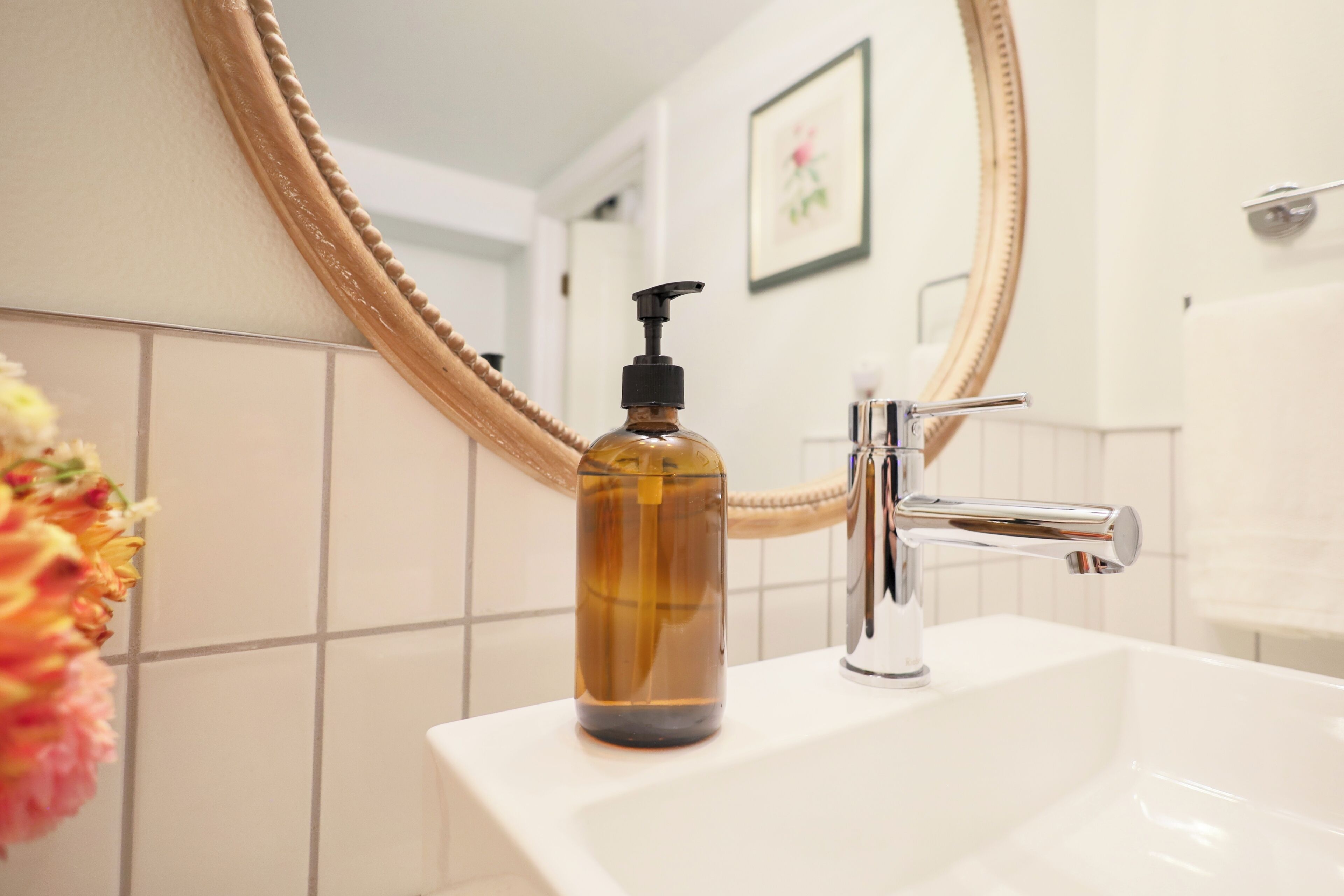 Un bagno con un lavandino bianco, un rubinetto cromato e un ampio specchio con motivo a corda.