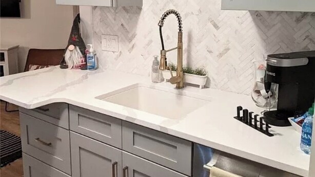A modern kitchen with a white countertop, grey cabinets, a herringbone-patterned backsplash, a pendant light, and a coffee maker. - Chic ski-in ski-out slopeside 1 bedroom condo at Holiday Valley resort sleeps 4. (Great Valley)