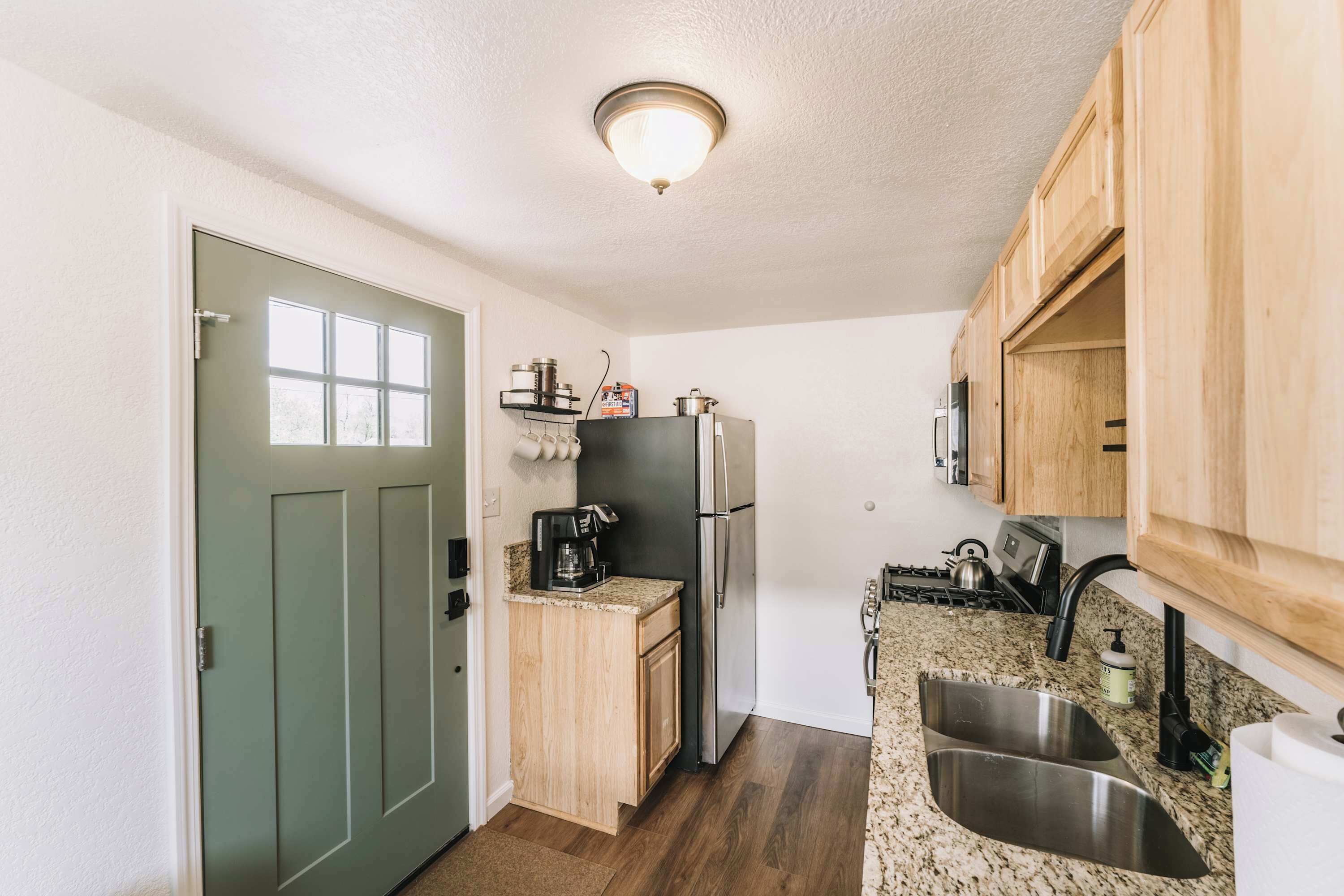 A compact kitchen with a refrigerator, stove, and sink.