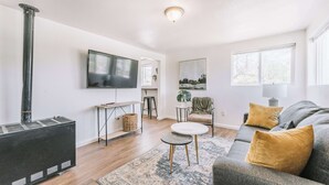 A living room with a fireplace, a flat-screen TV, a sofa, and a coffee table. - Prospect Point! Steps to Memorial Park w/ Hot tub (Colorado Springs)