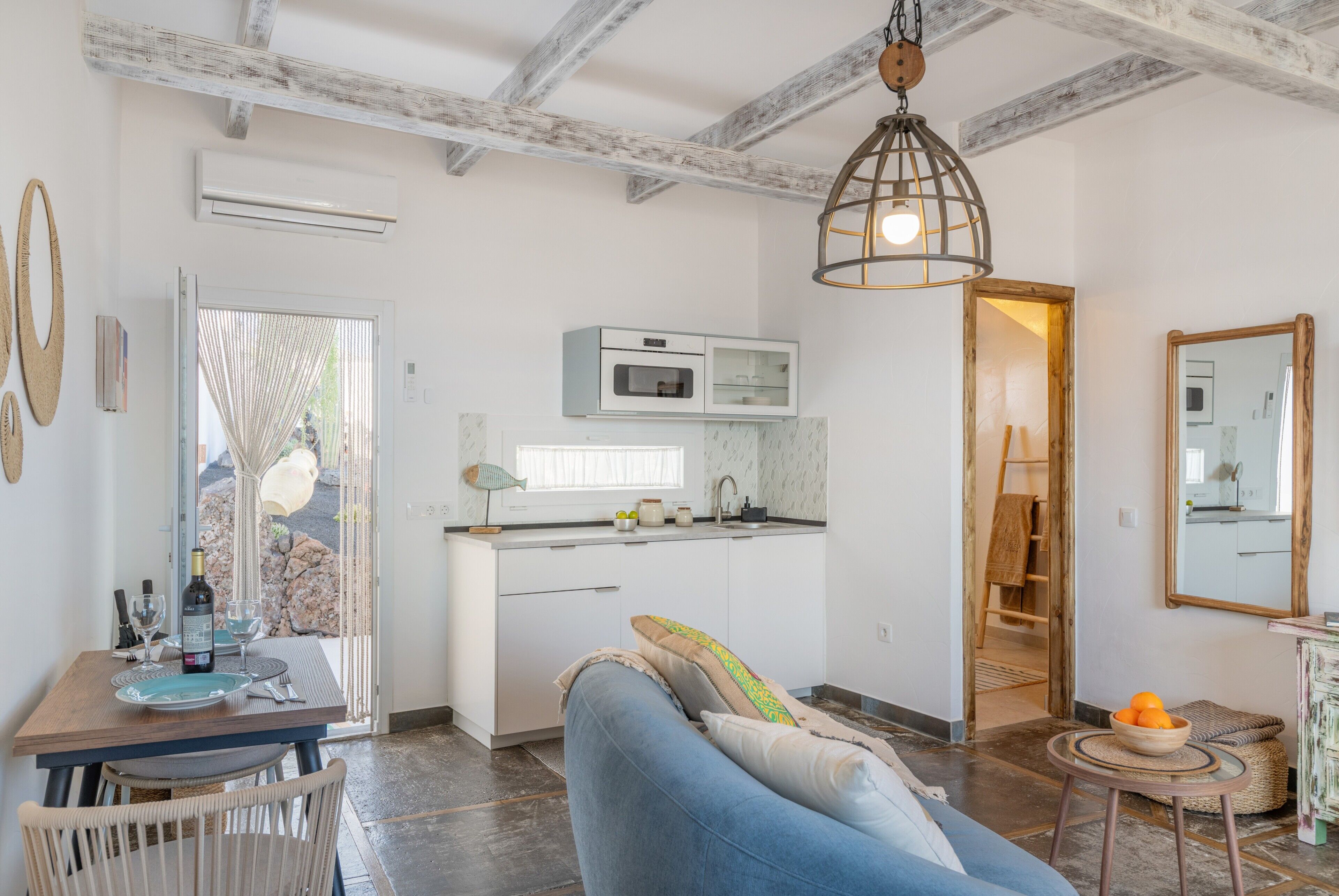 Una cocina moderna con armarios blancos, horno integrado y una ventana.