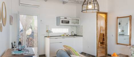 Una cocina moderna con armarios blancos, horno integrado y una ventana.