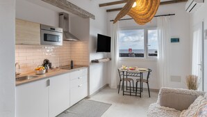 Et moderne køkken med indbygget ovn, mikrobølgeovn og stort vindue med havudsigt.