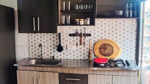 A modern kitchen with wooden cabinets, a stainless steel sink, and a tiled backsplash.