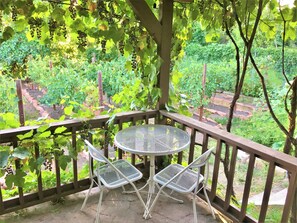 A balcony with a round metal table and two chairs, surrounded by a wooden railing. - 6-Bedroom Tudor in the Historic District (Salt Lake City)