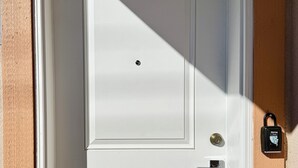 Une porte blanche avec un trou de serrure et un bouton de sonnette.