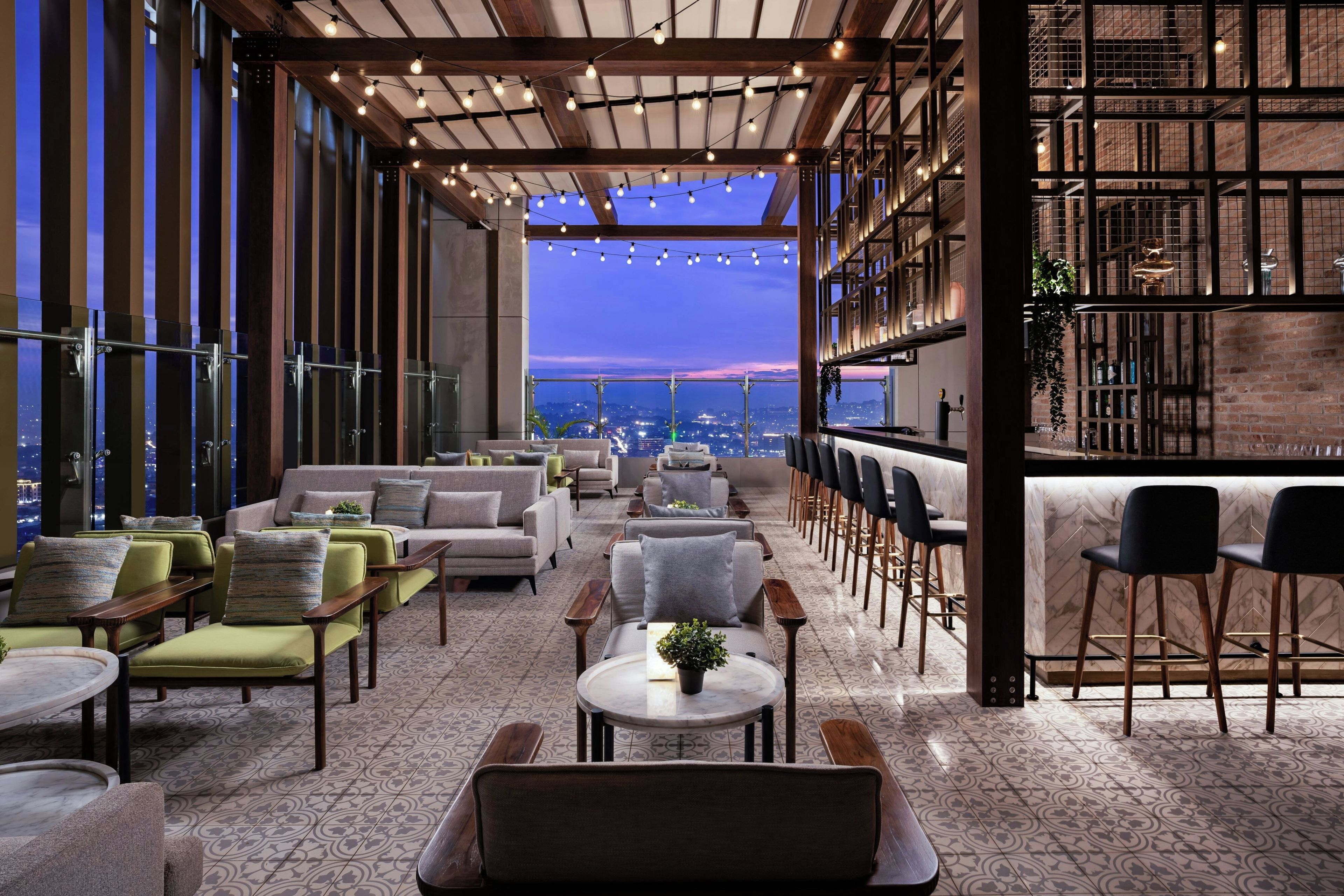 Una terrazza panoramica con zone relax, un bar e vista sulla città.
