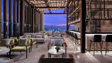 Una terrazza panoramica con zone relax, un bar e vista sulla città.