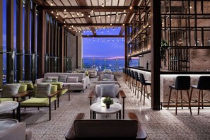 A rooftop lounge with seating areas, a bar, and a city view. - Marriott Executive Apartments Kampala (Kampala)