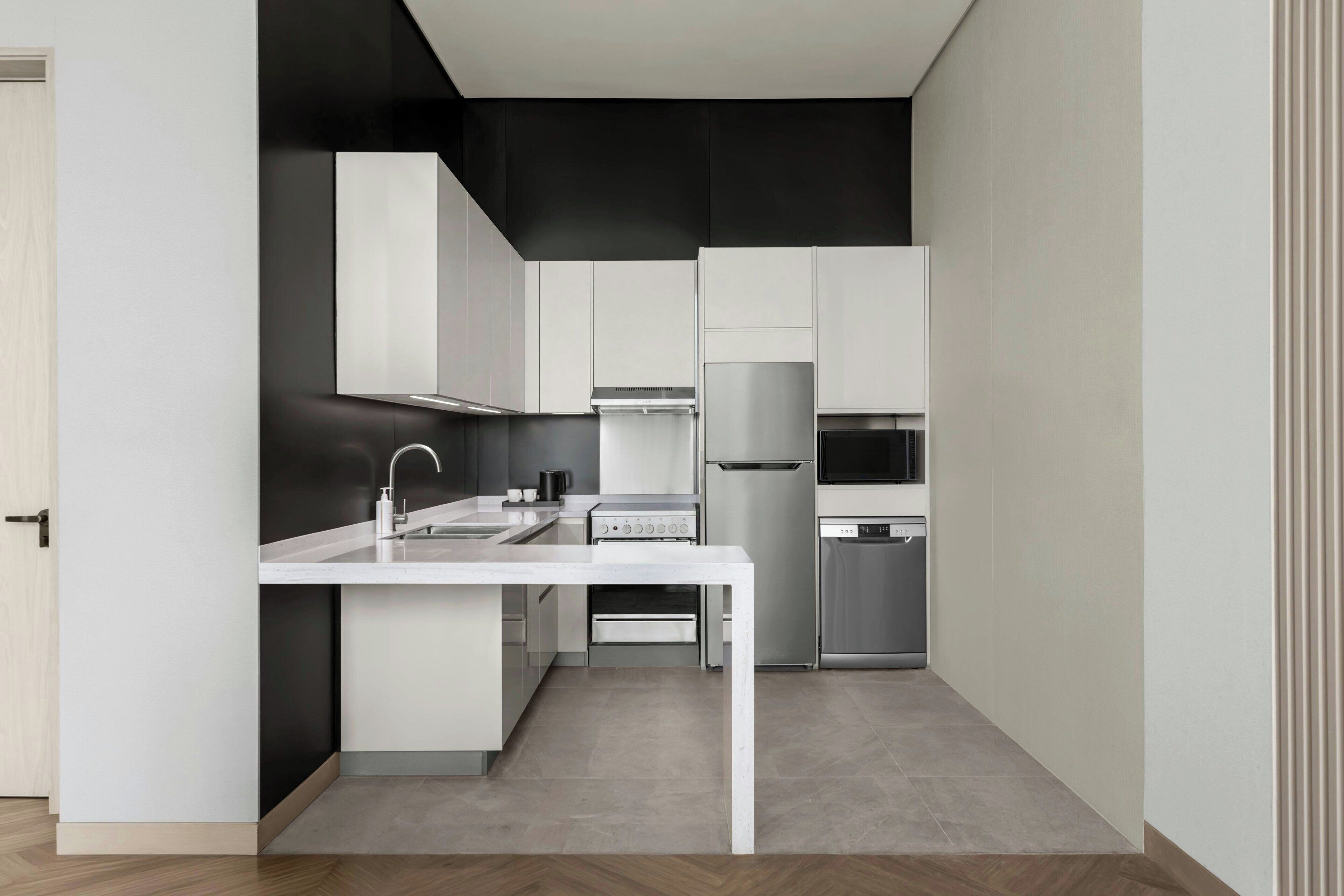 A modern kitchen with white cabinetry, a stainless steel range, and a built-in oven.