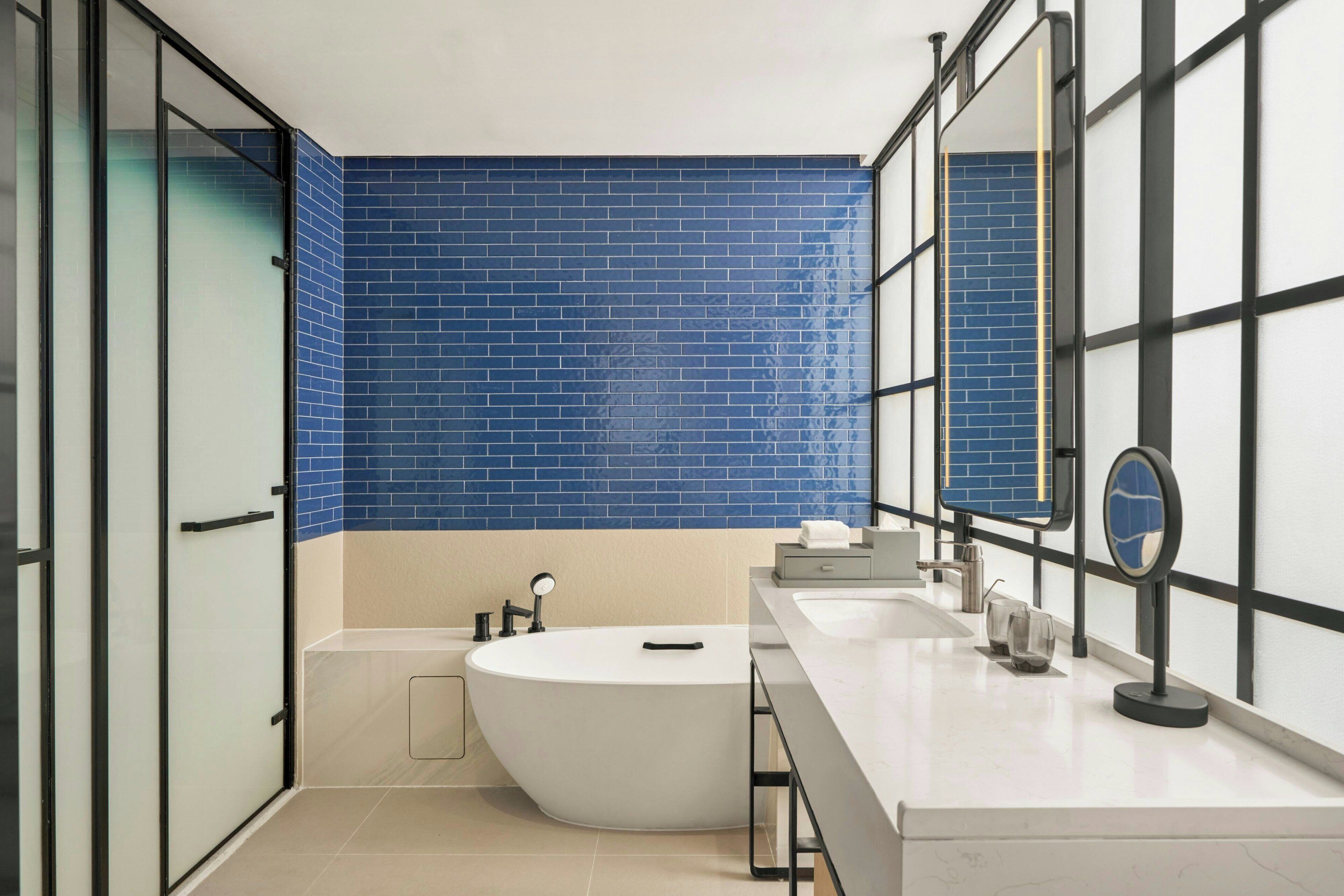 Un baño moderno con una bañera grande, un lavabo y un espejo.