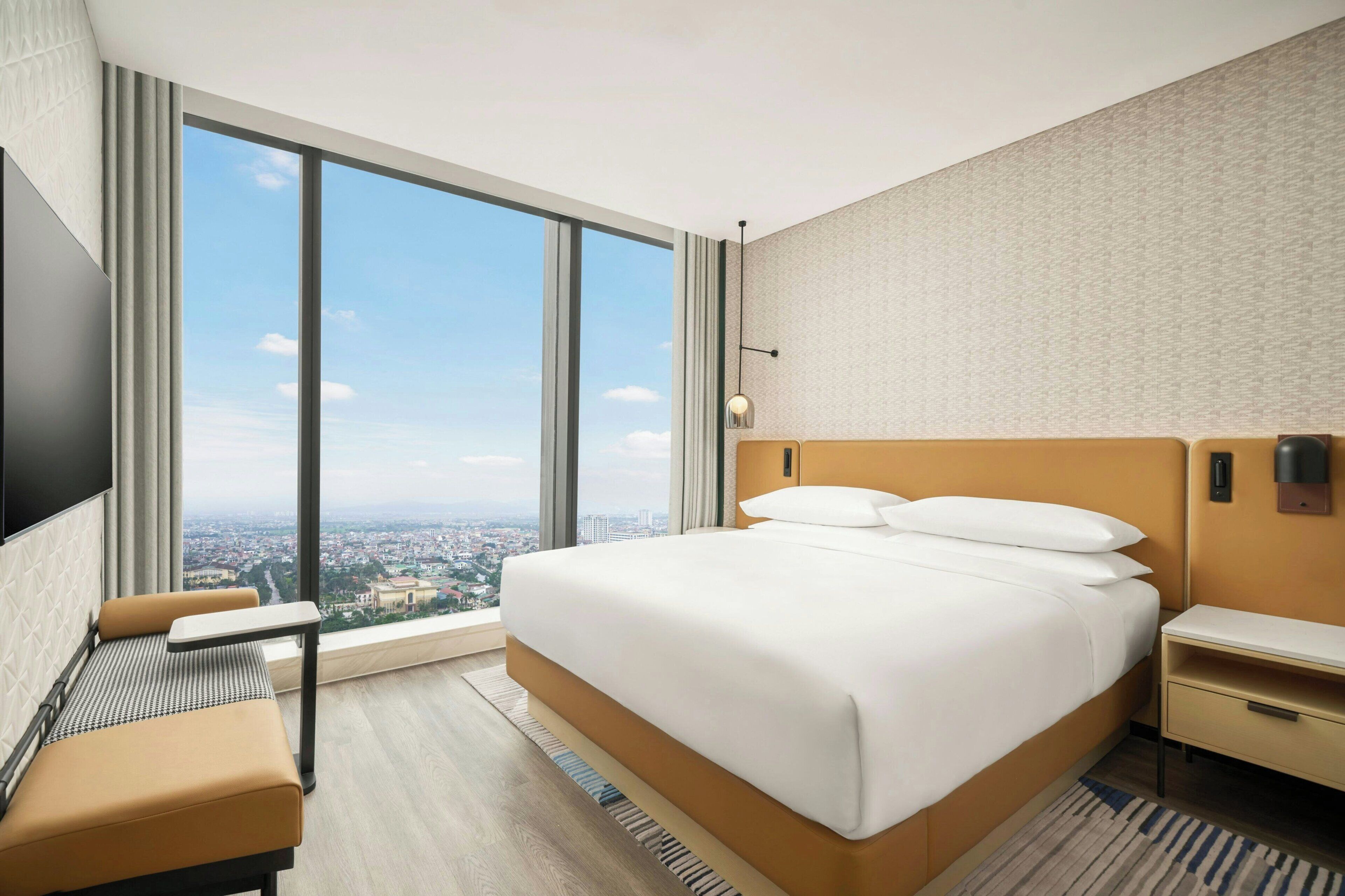 Una habitación de hotel con una cama grande, un escritorio, una silla y un televisor.