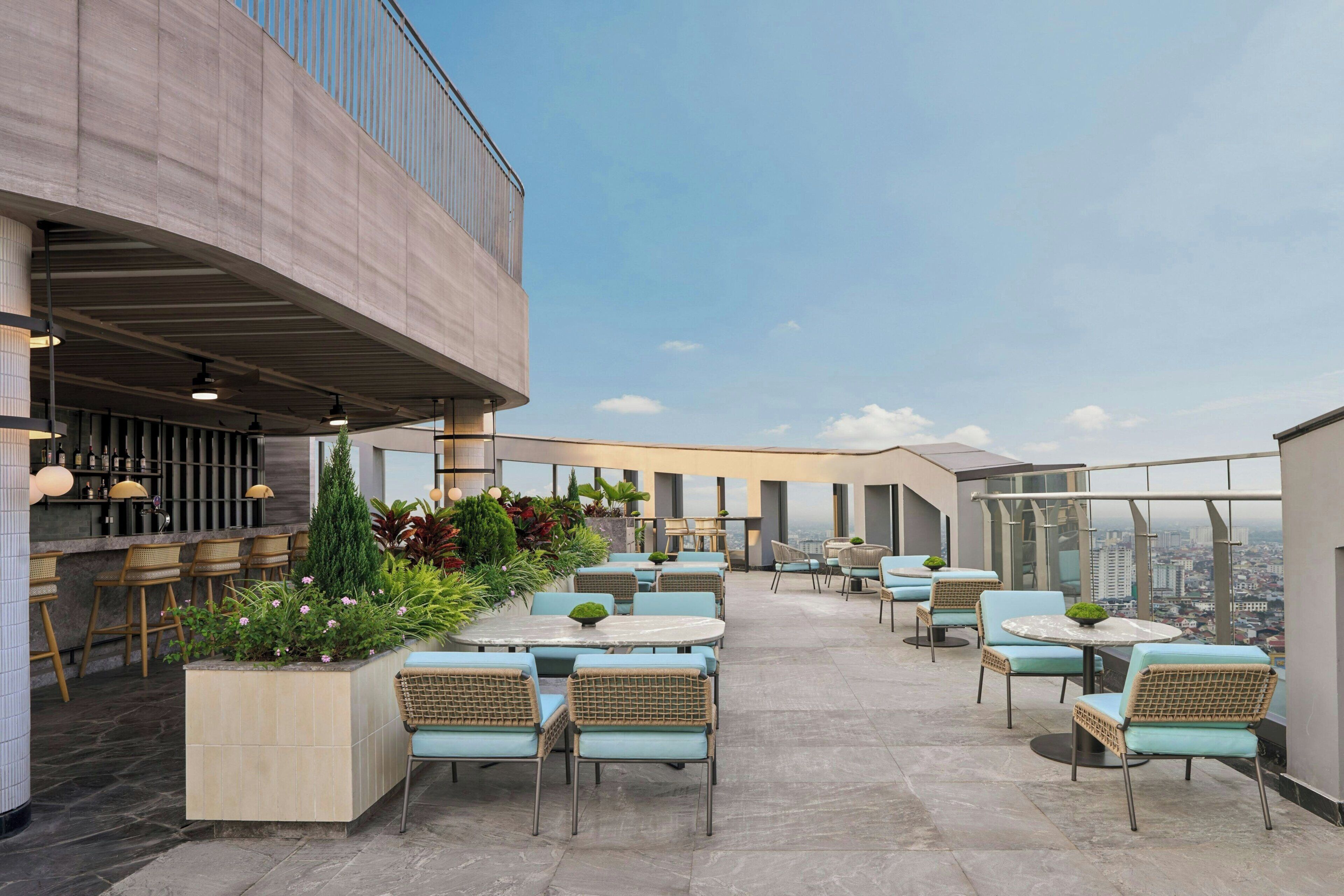 Un bar situé sur le toit, avec une terrasse, un espace bar et une vue sur la ville.