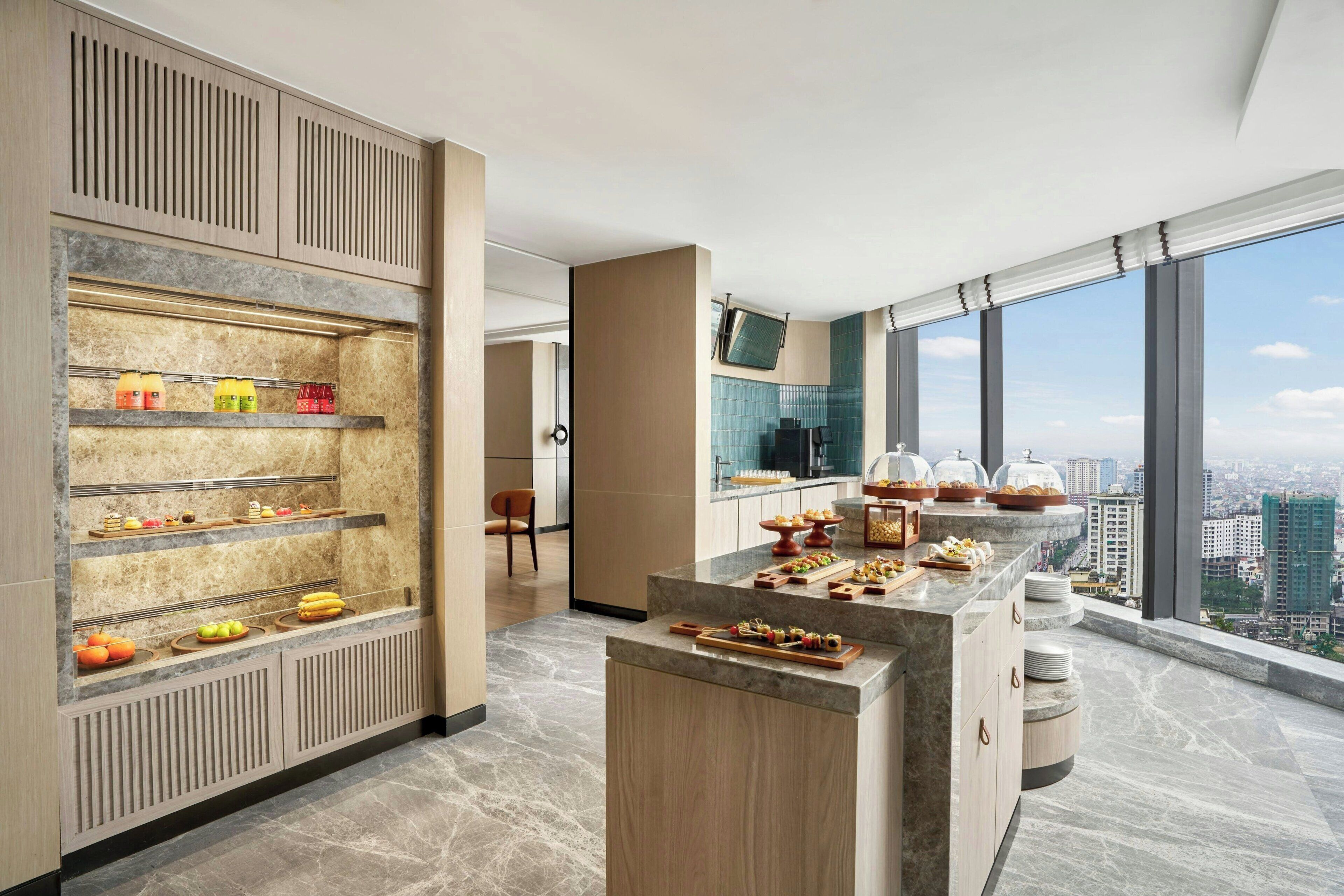 Eine moderne Küche mit Marmorarbeitsplatten, einem reichhaltigen Buffet und Blick auf die Stadt.