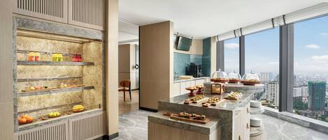 Eine moderne Küche mit Marmorarbeitsplatten, einem reichhaltigen Buffet und Blick auf die Stadt.