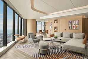 A modern living room with a sofa, armchairs, a coffee table, and a rug.