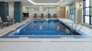 An indoor swimming pool with a no diving sign, lounge chairs, and a tiled wall. - Towneplace Suites By Marriott Montreal Airport (Dorval)