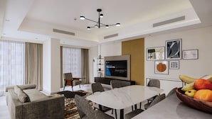 A modern hotel room with a dining area, a TV, and artwork on the walls. - Marriott Executive Apartments Jumeirah Lakes Towers, Dubai (Dubai)