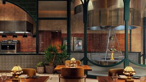 A restaurant with brick walls, wooden tables, and hanging pendant lights. - W Riyadh - KAFD (Riyadh)