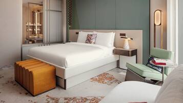 Une chambre d’hôtel moderne avec un grand lit, une table de chevet, une commode, un banc, un miroir et une vue sur la salle de bain.